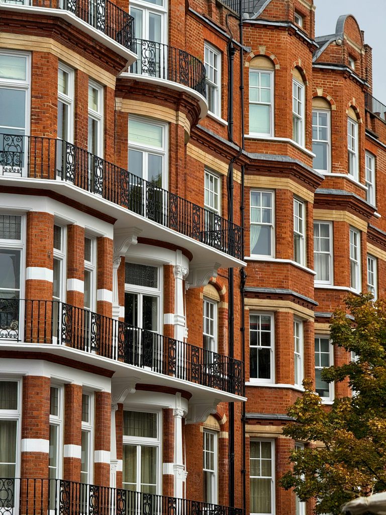 Classic red brick architecture with ornate balconies in Kensington, London.
